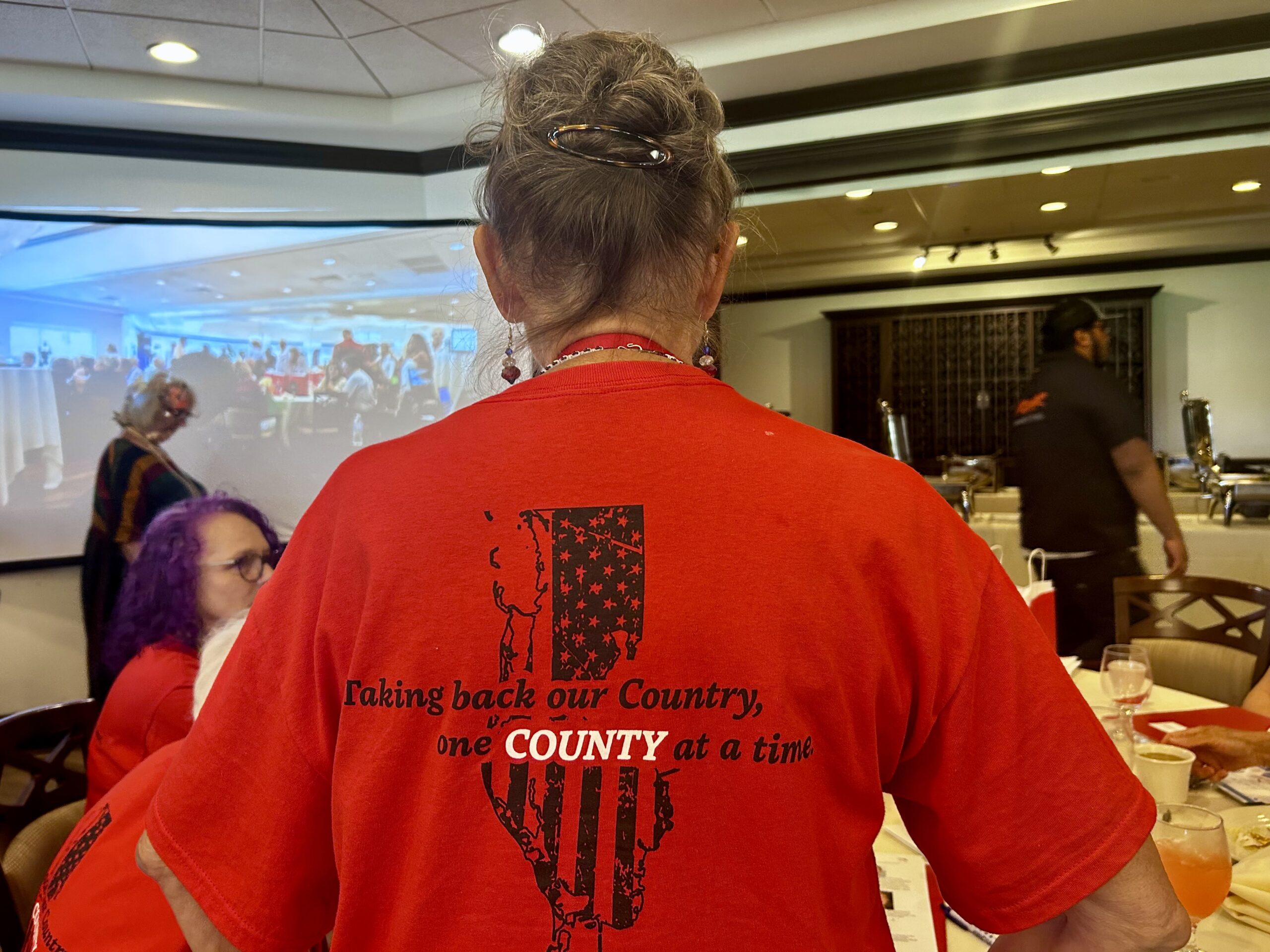 PinellasWatchdogs The back of a woman's red t-shirt with a map of Pinellas County that reads "Taking back our country, one COUNTY at a time."