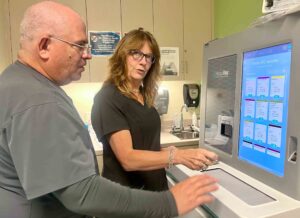 Lisa Gonzalez-Abello, pediatrician and chief medical officer for CenterPlace Health, and Eduardo Ramos, RN, load vaccinations into a refrigerated storage container.