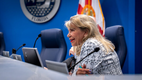 A seated woman speaks into a microphone
