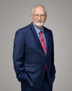 A man is shown from the waist up, looking at the camera