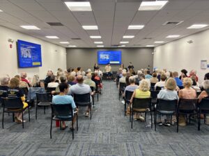 A conference room full of people, photographed from behind.